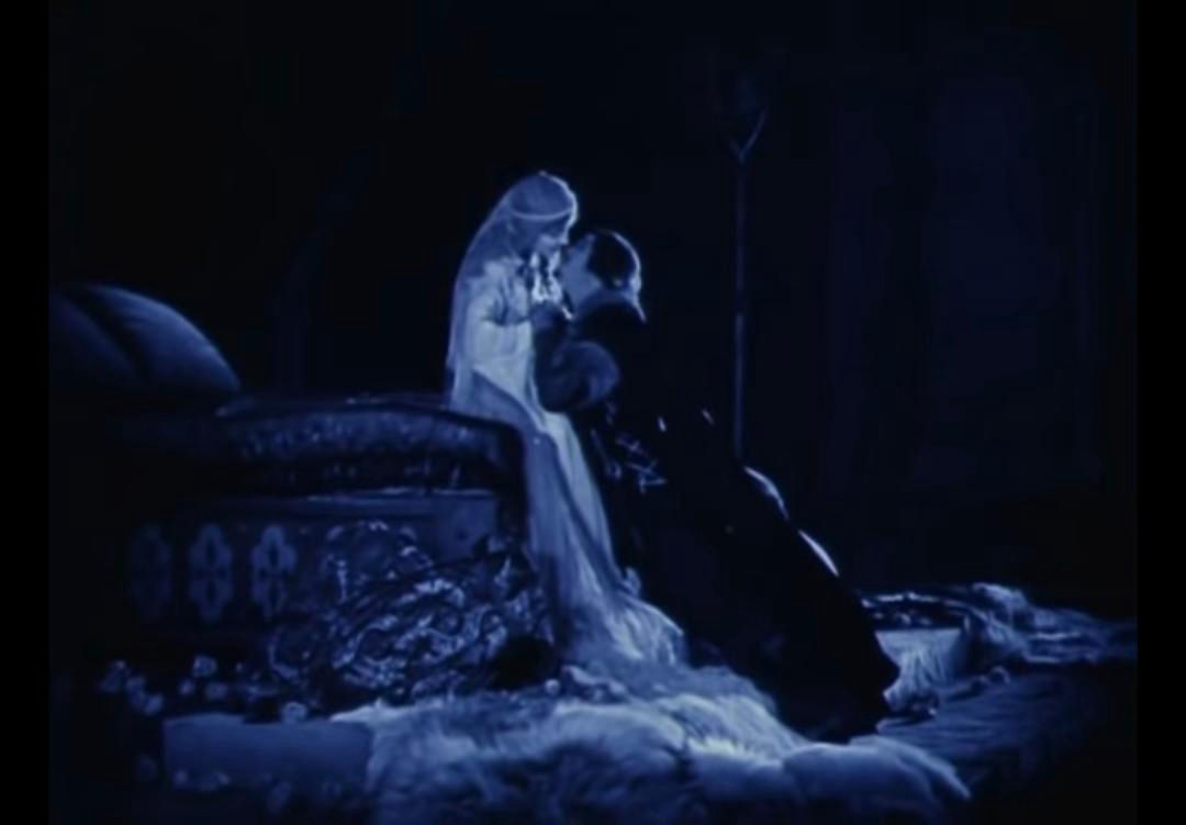 Douglas Fairbanks as Robin Hood and Enid Bennett as Marian embrace on their wedding bed